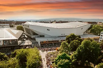 Aerial view of the Wiener Stadthalle at dusk, with people waiting to enter.