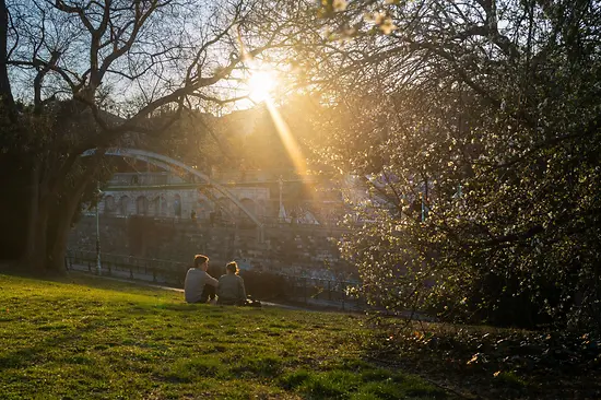 A couple sits in the city park enjoying the spring atmosphere