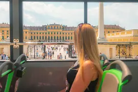 Young woman in a sightseeing bus in front of Schönbrunn Palace