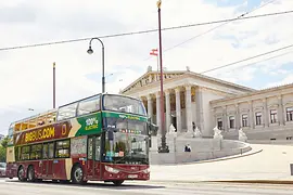 Red hop-on hop-off double-decker bus by Big Bus Tours in front of the Parliament