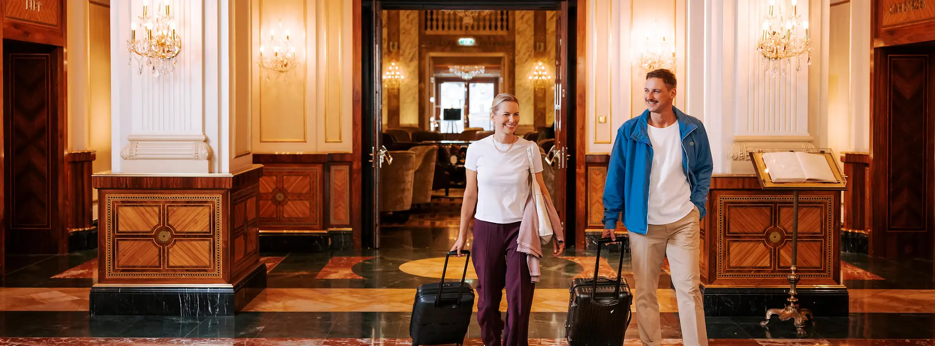 Two people with luggage in a Viennese hotel