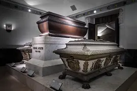 Caskets in illuminated room, plinth bearing inscription Franz Joseph