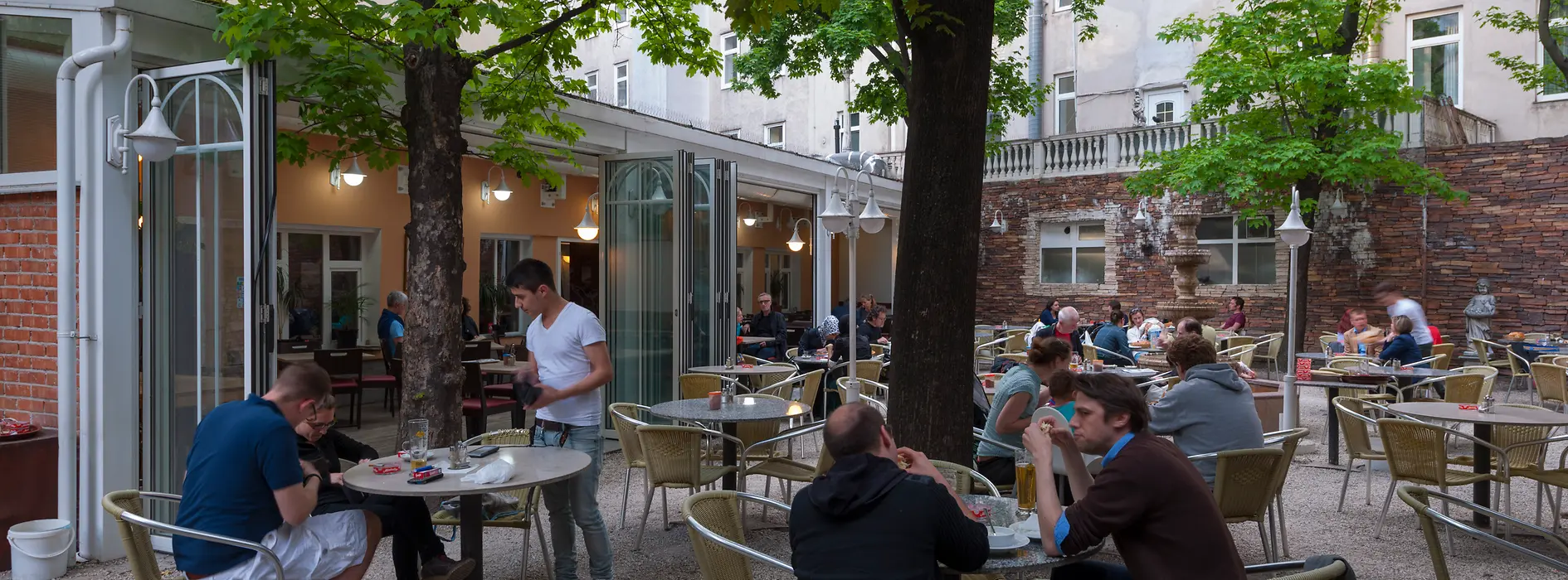 Restaurant Vincent, interior shot with a view of the outdoor dining area with guests 