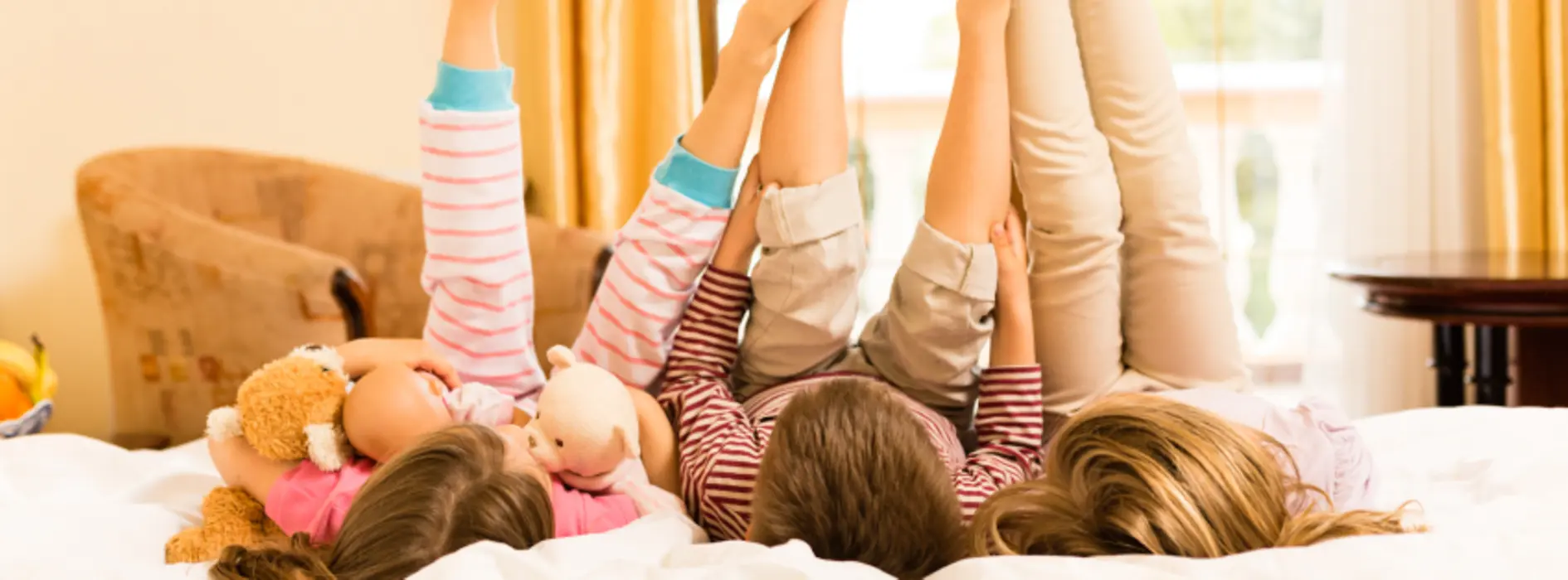 Kinder liegen auf Hotelbett
