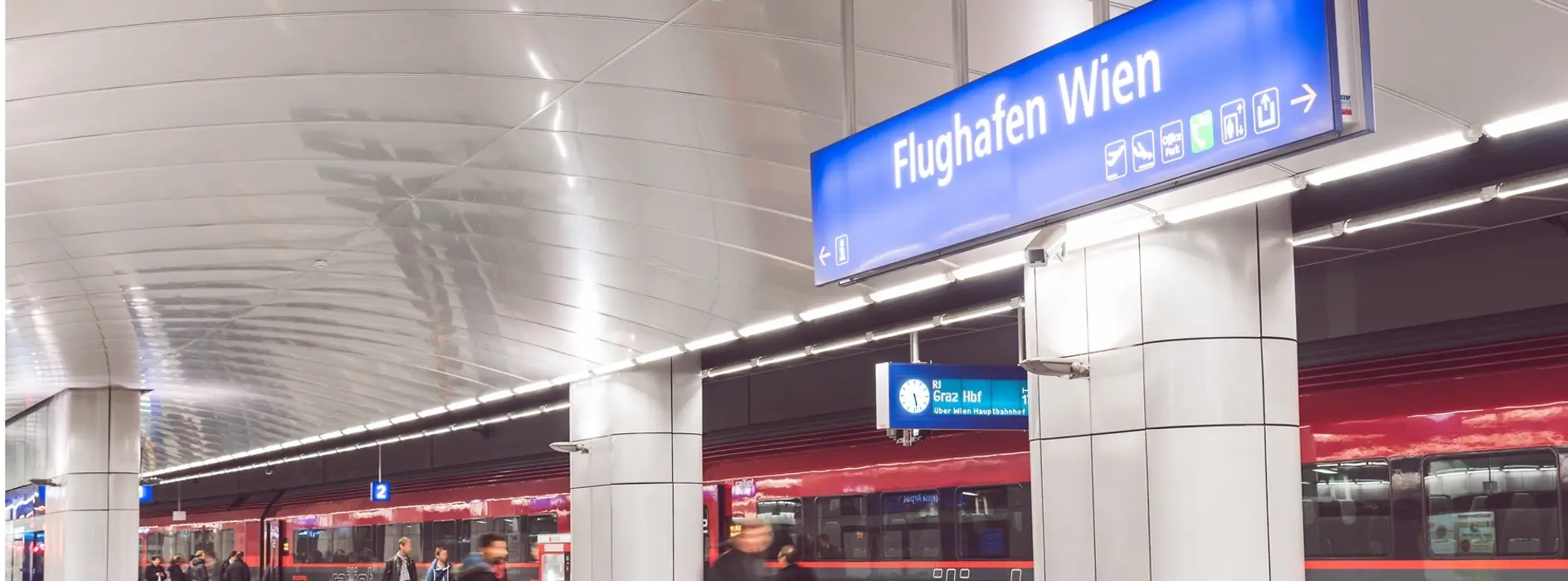 ÖBB Railjet na stacji lotniskowej z podróżnymi na pierwszym planie