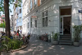 Pizza Mari in the Karmeliter district, exterior shot with guests in the outdoor dining area 