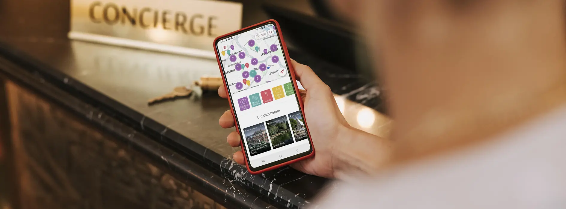 A man is standing in front of reception, with the ivie app open on his cell phone
