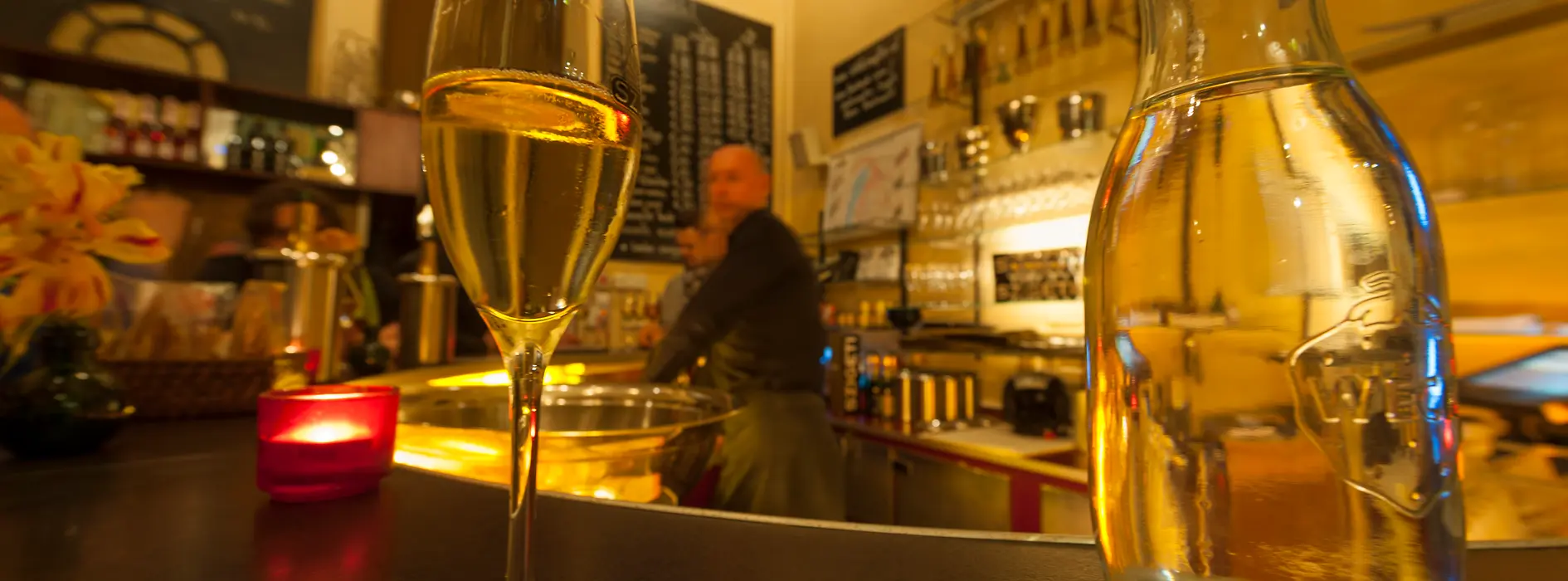 Szigeti Sektcomptoir, interior shot with a glass of sparkling wine and guests 