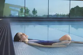 Frau relaxt im Wasser der Therme Wien