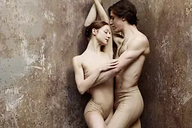Ballet couple posing entwined in a corner