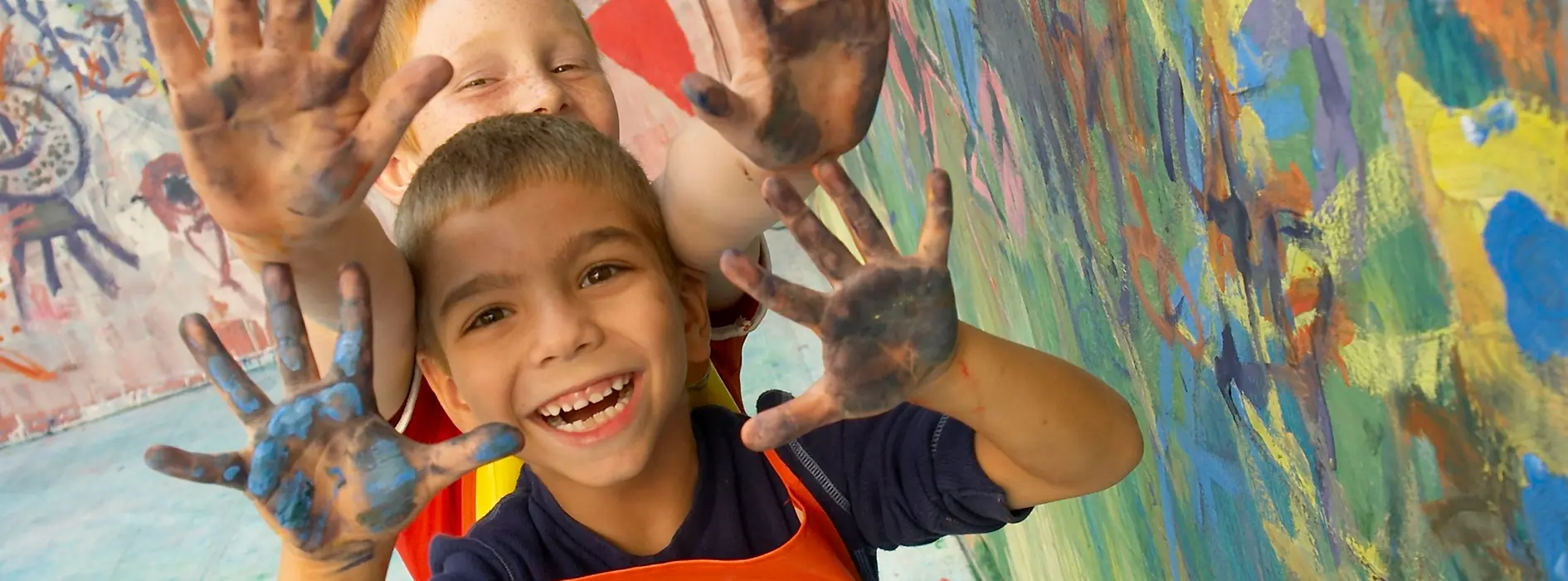 Two boys with hands full of colour