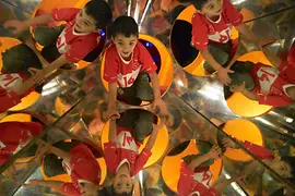 Boy scrambling through mirror tunnel