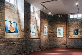 Pictures on the wall of the gallery in the basement of Gayt