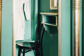 Changing cubicle with chair, bathrobe, and mirror in the Kaiserbründl men's sauna