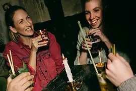 Four people with drinks at a table with candle