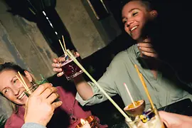 Four people with drinks at a table with candle