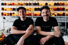 Deux hommes assis devant deux grands bocaux