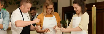 Menschen bereiten ein Wiener Schnitzel zu
