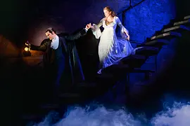 El fantasma conduce a Christine escaleras abajo.
