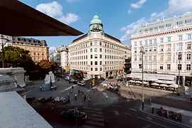 位于阿尔贝蒂娜广场的维也纳旅游咨询处的外观，门前的出租马车和行人