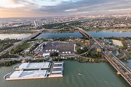 Letecký pohled na Donauinsel během Donauinselfestu s davy lidí, pódií a stany