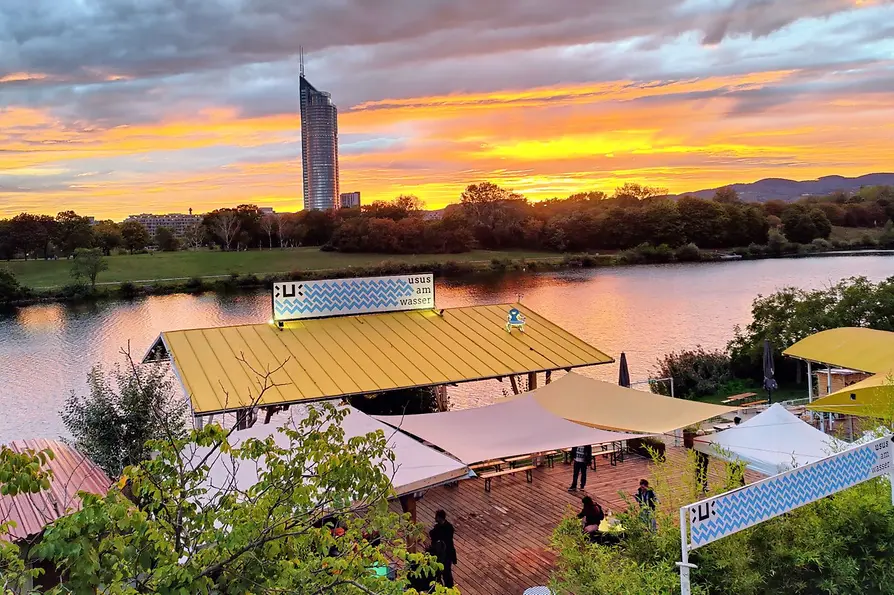 Schanigarten, Usus on the waterfront, Vienna skyline with sunset in the background