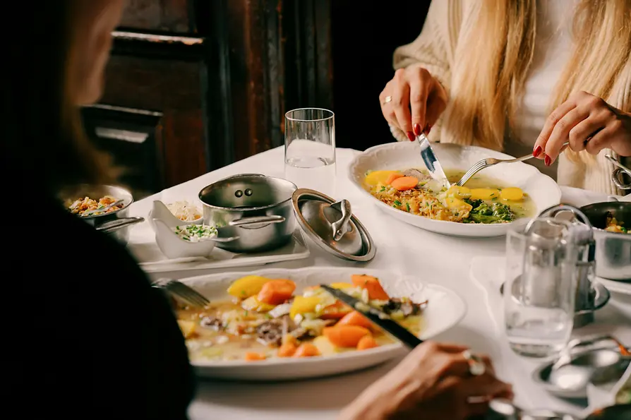 Donne che mangiano Tafelspitz a una tavola apparecchiata con gusto