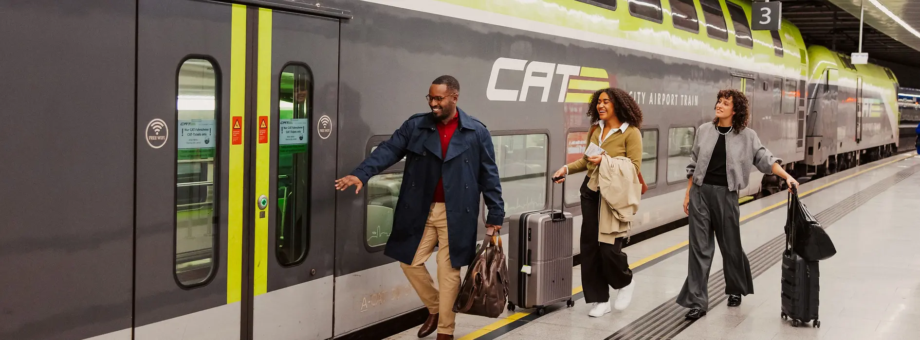 Dos señoras y un caballero suben al tren expreso del aeropuerto City Airport Train. 
