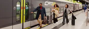 Zwei Damen und ein Herr beim Einsteigen in den Flughafen-Express Zug City Airport Train. 