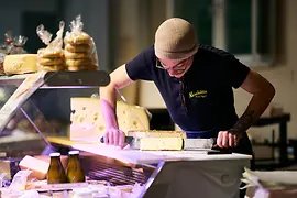 Man cuts a piece of cheese