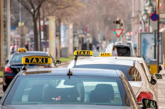 Cab rank in Vienna on the Ringstrasse with several cabs with signs (black with yellow lettering)
