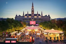 Evening aerial view of the 2025 Film Festival in front of Vienna City Hall with numerous stalls.
