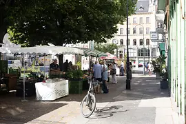 Scène de rue sur la place Margareten à Vienne avec des stands de marché et un vélo garé