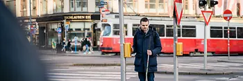 Blind person uses acoustic-tactile traffic light.